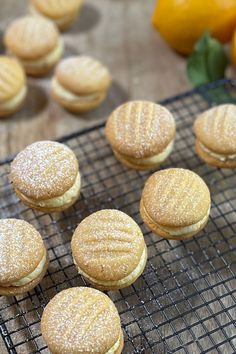 several cookies on a cooling rack with oranges in the background