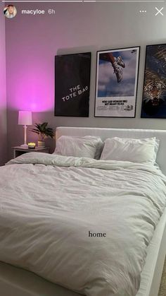 a white bed sitting in a bedroom next to two pictures on the wall above it