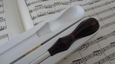 a pair of wooden spoons in a box with sheet music