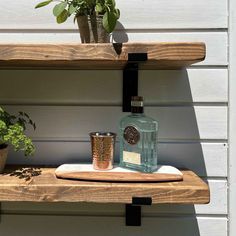 a bottle of gin on a shelf next to a potted plant and a glass