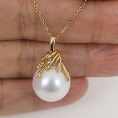 Lovely "In-House' designed pendant, made of solid 14K yellow gold with six- earth mined small accent diamonds and a organic natural "white" Edison cultured pearl.    The enormous 15.2 x 16.5mm pearl exhibits an excellent high luster and thick nacre with just a minimal, mild natural birthmarks; refer to the photos of the actual pendant for detail. Style:  Pendant Precious Metal: Solid 14k yellow gold Genuine Diamond: 6 pcs / 0.030ctw.   --------------------   Pearl:  Freshwater Cultured Pearl Typ Yellow Pearl Necklace, Pearl Pendent Designs, Small Pendent Designs Gold, Pearl Necklace With Pendant, Pearl Pendant Designs Gold, Pearl Pendant Designs, Trendy Watches Women Fashion, Single Pearl Pendant, Small Pendants