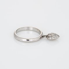 Finely detailed pre owned Tiffany & Co pave diamond heart charm ring crafted in platinum.   Diamonds are pave set into the heart and total an estimated 0.15 carats (estimated at F-G colour and VVS2 clarity).   The stylish ring features a diamond set heart, suspended from the band to allow for movement. The ring is impactful in design and ideal worn day or night. The ring was originally available at Tiffany & Co approx. ten years ago and has since been retired from retail.   The ring is in fair c Formal Heart-shaped Diamond Ring, Heart Cut Diamond Rings With Single Cut Diamonds, Heart-shaped Brilliant Cut Diamond Ring, Formal Heart-shaped Diamond Ring With Accents, Formal Heart Shaped Diamond Ring With Accents, Heart Shaped Brilliant Cut Diamond Ring, Pear-shaped Diamond Ring With Pave Setting, Formal White Gold Cubic Zirconia Heart Ring, Heart Shaped White Gold Diamond Ring With Vvs Clarity