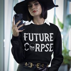 Future Corpse Sweatshirt  This soft and comfy Halloween sweatshirt will keep you warm. Use it as a way to showcase your Halloween spirit on trick o treating night or wear it anytime.  Perfect for busy moms or anyone with a smirking sense of humor.  Please note the estimated shipping dates. COLOR: Black Please note that the color of this sweatshirt may appear in a slightly different shade due to the lighting in which these photos were taken. This is a UNISEX-style fit. Please double and triple-ch Alternative Long Sleeve Halloween Sweater, Alternative Black Halloween Sweater, Alternative Style Black Halloween Sweater, Punk Halloween Sweater For Streetwear, Halloween Punk Style Streetwear Sweater, Alternative Style Halloween Sweater For Streetwear, Alternative Crew Neck Fall Sweater, Halloween Skull Print Sweatshirt For Streetwear, Halloween Punk Long Sleeve Sweater