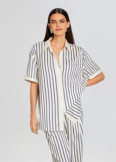 Upgrade your wardrobe in SER.O.YA's Davey Blouse. Designed for effortless style and comfort, this short sleeve striped button down shirt features a classic collar and loose fit, making it the perfect addition to your everyday rotation. Pair with the Dixon Pant. Shown here in Navy/Ivory Stripe. 100% Polyester Made in Ch Relaxed Fit Striped Collared Blouse, Striped Collared Blouse Relaxed Fit, Striped Collared Blouse With Relaxed Fit, Vertical Stripes Button-up Shirt For Day Out, Relaxed Fit Vertical Stripes Button-up Blouse, Vertical Stripes Shirt For Summer Workwear, Short Sleeve Vertical Stripe Workwear Blouse, Short Sleeve Vertical Stripes Blouse For Work, Chic Striped Shirt For Daywear