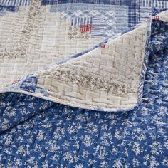 a blue and white quilt on top of a bed