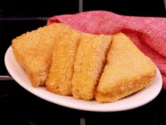 four pieces of fried food on a white plate