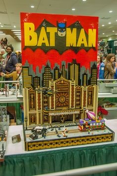 the batman poster is on display in front of many other people at an indoor event