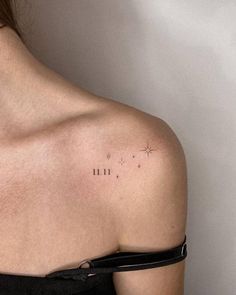 the back of a woman's shoulder with small stars on her left arm and an inscription written in cursive writing