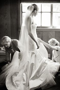 a woman in a wedding dress getting ready to walk down the aisle with her bridesmaids