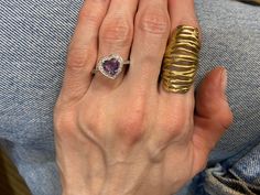 a woman's hand with a gold ring and amethyst garter on it