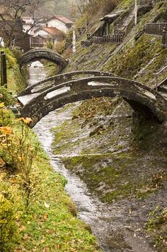 an old stone bridge over a small stream