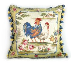 a cross stitch pillow with a rooster on it