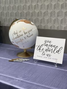 a table topped with a white globe and a sign that says, you are the world to us