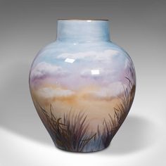 a painted vase sitting on top of a white table