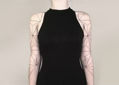 a woman wearing a black dress with geometric designs on it