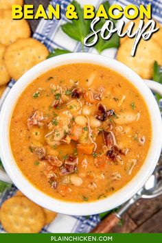 a bowl of bean and bacon soup with crackers on the side