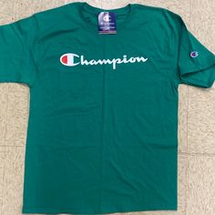 This Champion Shirt Is A Wonderful Green In Color And A Medium In Size . This Is An Irregular Stamped At Company . All The Regular Stuff Is Therr . Relaxed Fit Green Shirt With Text Print, Green Crew Neck Cotton Shirt, Green Cotton Shirt With Letter Print, Summer Long Sleeve Shirt With Logo Print, Green Cotton Crew Neck Shirt, Green Letter Print Shirt For Streetwear, Green Logo Print Shirt For Summer, Green Logo Print Summer Shirt, Green Cotton Shirt With Text Print