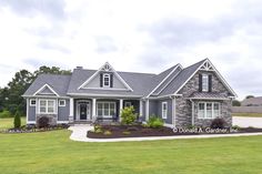 a large gray house sitting on top of a lush green field