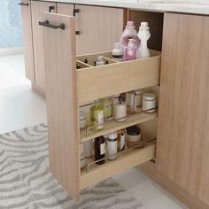 an open cabinet in a bathroom with lots of bottles and containers on the bottom shelf