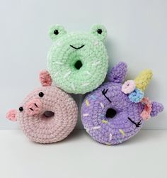 three crocheted donuts are sitting next to each other