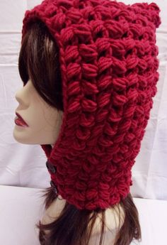 a crocheted red hat on top of a mannequin's head