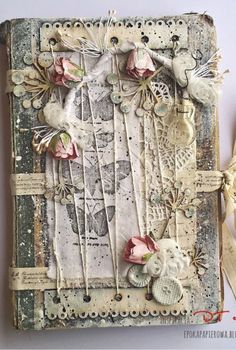 an altered book with flowers and ribbons on it