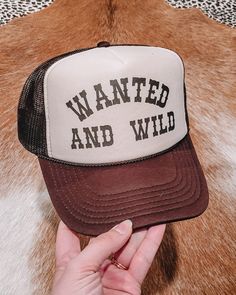 Wanted And Wild Trucker Hat – Rockin' T Boutique Summer Casual Trucker Hat For Country Events, Casual Summer Trucker Hat For Country Events, Casual Trucker Hat For Country Events In Spring, Trendy Brown Hat With Letter Print, Summer Rodeo Trucker Hat, Trendy Summer Trucker Hat With Graphic Print, Trendy Graphic Print Trucker Hat For Summer, Retro Brown Trucker Hat With Letter Print, Trendy Summer Trucker Hat For Country Events