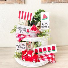 a red truck is sitting on top of a white plate with flags and other decorations