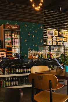 the interior of a coffee shop with wooden chairs and lights hanging from the ceiling above