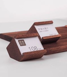 two wooden business cards sitting on top of each other in front of a white background