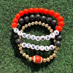 three different bracelets with the word cincinnati and football beads on top of each other