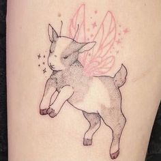 a small tattoo of a cat with wings on it's back side, and stars in the background