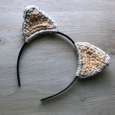 a crocheted cat ears headband on top of a wooden table