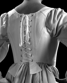 "Our c.1790 Marie is designed to be worn with the \"Round Gowns\" of the late eighteenth-century. Adjustable with both center front and center back lacings, the corset shapes in under the bust. The length is cut to sit above the waist, controlling the torso through the ribcage. The boning is firm 5/16\" steel. This corset has shoulder straps attached with adjustable front lacing. Features include: Ø Side seam alteration point for an adjustable fit Ø Center front and back lacing Ø Shoulder straps Regency Style Historical Wedding Corset, Regency Style Fitted Bodice With Corset Back, Regency Style Wedding Corset With Historical Design, Regency Style Wedding Corset Dress With Corset Back, Regency Style Corset Back Wedding Dress, Regency Style Corset Back Dress For Wedding, Regency Style Overbust Corset Dress With Historical Design, Regency Style Corset Dress With Corset Back For Wedding, Regency Style Corset Dress For Costume Events