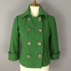 Women's CAbi green wool blend peacoat jacket. Double breasted button closure. Side pockets. Fully lined. Cropped length with 3/4 sleeves. Good pre-owned condition- minor pilling. Women's size 2. 18.5 inches armpit to armpit laying flat. 17 inches across waist laying flat. 14.5 inches shoulder to shoulder. 21 inches top of shoulder to bottom hem. 18 inch sleeve length. Retro Double-breasted Outerwear With Button Closure, Retro Long Sleeve Pea Coat With Buttons, Retro Fall Pea Coat With Button Closure, Retro Long Sleeve Pea Coat, Vintage Long Sleeve Pea Coat With Button Closure, Green Double-breasted Outerwear With Pockets, Green Long Sleeve Pea Coat For Fall, Green Button-up Outerwear With Double Button Closure, Retro Long Sleeve Pea Coat For Fall