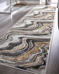 an area rug with black, yellow and white designs on the floor in a living room