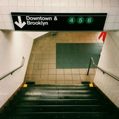 an escalator with a sign above it that says downtown and brooklyn