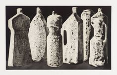 five vases are lined up in a row on a black and white background,