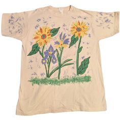 "Step back into the bold and artistic fashion of the 1980s with this hand-painted Brush Works T-shirt. Its vibrant design features yellow and orange flowers with green foliage, accented with puffy paint and jewels on a cream background. Sized as one size fits all, resembling an XL, it's in very good condition and is a statement piece for any vintage wardrobe. - Collection: 1980s Brush Works - Style: Hand-Painted Floral Design with Puffy Paint and Jewels - Base Color: Cream - Size: One size fits Artsy Printed T-shirt For Spring, Multicolor 90s T-shirt For Spring, 90s Style Multicolor Spring T-shirt, Casual Hand Painted Cotton Tops, 90s Style Multicolor T-shirt For Spring, Casual Cotton Hand Painted Tops, 90s Style Green T-shirt For Spring, Yellow Graphic Tee With Floral Print, 90s Printed T-shirt For Spring