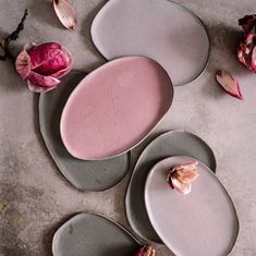 three plates with pink and grey designs on them, one has a flower in the middle