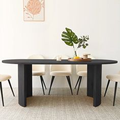 a black table with white chairs and a potted plant in the middle is shown