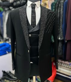 a suit and tie are on display in a clothing store, with other items behind it