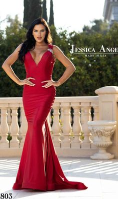 Behold the beauty of this v-neck long mermaid prom dress 803 by Jessica Angel. With a sparkly brooch at one shoulder strap, this deep v-neck long designer dress gets a hint of shimmer with every move at prom, galas, and other black-tie events. In misses and plus sizes, this long formal dress has a horizontal band in the back of the neck that beautifully frames the open v-back, while the hip-skimming long mermaid skirt ends in a sweeping train. Made in the USA, this v-neck long mermaid prom dress V-neck Mermaid Dress With Sweep Train And Fitted Bodice, Fitted V-neck Mermaid Dress With Sweep Train, V-neck Gown For Red Carpet And Prom Season, V-neck Mermaid Dress With Fitted Bodice For Prom, Elegant Red Carpet Dress With Back Opening, Red V-neck Mermaid Dress For Prom, Fitted Dress With Back Opening For Red Carpet, Elegant Backless Red Carpet Gown, Elegant Red Carpet Gown With Mermaid Hem