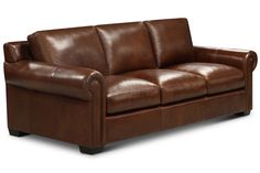 a brown leather couch sitting on top of a white floor