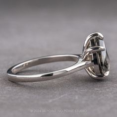 a close up view of a ring with a stone in the center on a gray surface