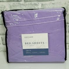 a purple bed sheet sitting on top of a white counter next to a brick wall