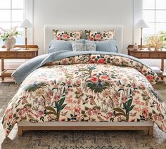 a bed with floral comforter and pillows in a room