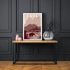 a table with a vase on top of it and a poster above it that says laos