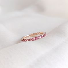 This stunning full eternity ring is set in 14k Solid Yellow Gold with Natural Pink Tourmaline with utmost precision. It is an unique dainty gemstone ring for nearly every occasion and is completely hassle-free jewelry. ITEM DETAILS * Gem: Pink Tourmaline * Gem Size: 2mm * Gem Shape: Round * Gem Weight: 1.00 carats * Gold Purity: 14KT * Gold Weight: 1.44 gram * Total Weight of the Ring: 1.64 gram The Gold purity is guaranteed and it comes with authentic 14KT gold hallmark. Since my items are handmade, they are absolutely nickel and lead free. CUSTOMIZATION * Gemstone customization is available, it can be substituted with a gem of your choice. It is available in gemstones such as Amethyst, Topaz, Onyx, Citrine, Garnet, Aquamarine and many more. Kindly drop me a message for  the same. PACKAGI Pink Round Cut Eternity Band For Promise Ring, Pink Round Cut Eternity Band Promise Ring, Pink Stackable Eternity Band As Gift, Pink Round Cut Eternity Band As Gift, Pink Gemstone Eternity Band For Anniversary, Pink Round Eternity Band For Promise Ring, Eternity Band With Accent Stones As A Gift, Round Eternity Band With Accent Stones As Gift, Pink Half Eternity Round Band