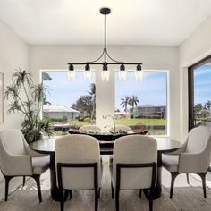 a dining room table with four chairs and a chandelier